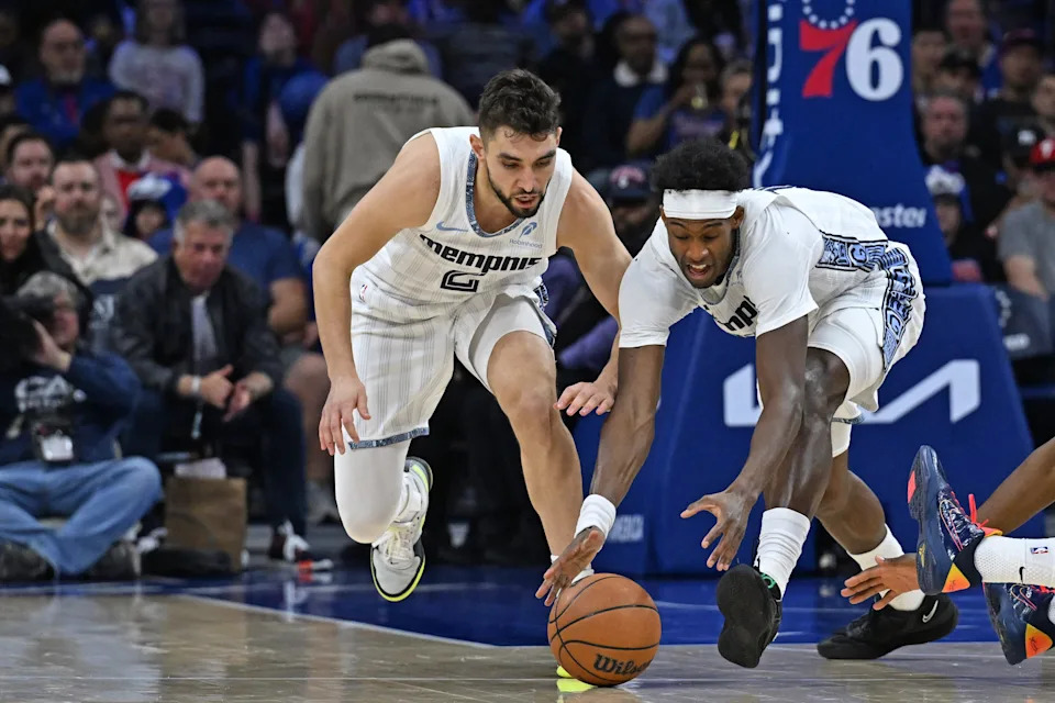 Mar 10, 2026; Philadelphia, Pennsylvania, USA; Memphis Grizzlies guard Ty Jerome (2) and forward Olivier-Maxence Prosper (18) reach for loose ball against the Philadelphia 76ers during the first half at Xfinity Mobile Arena. Mandatory Credit: Eric Hartline-Imagn Images