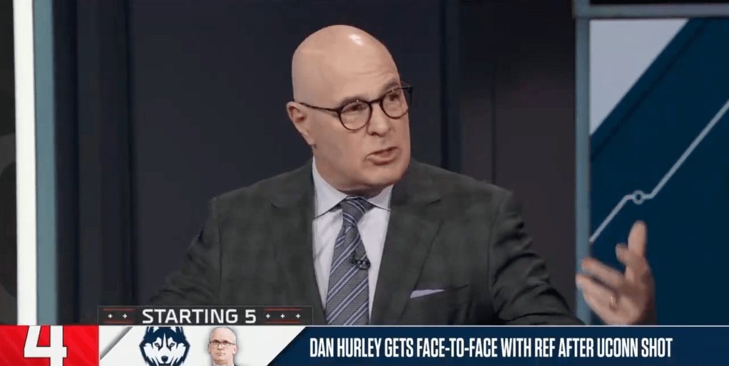 A man in a suit and glasses speaks on a television program with the text "DAN HURLEY GETS FACE-TO-FACE WITH REF AFTER UCONN SHOT" at the bottom.