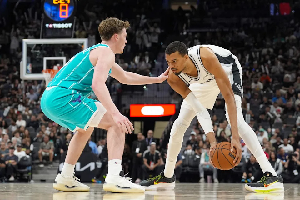 San Antonio Spurs forward Victor Wembanyama (1) holds the ball in front of Charlotte Hornets guard Kon Knueppel. Daniel Dunn-Imagn Images