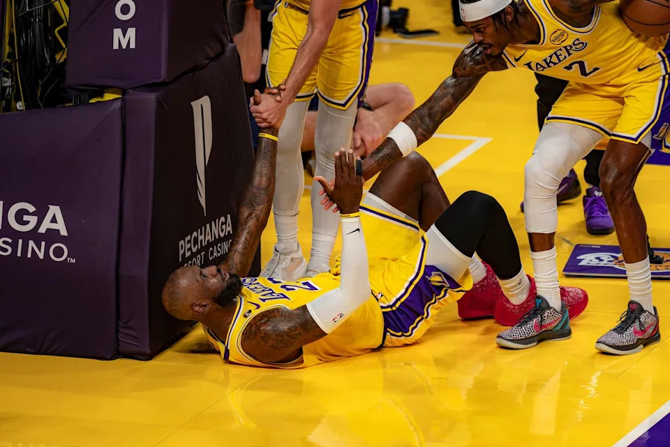 Los Angeles Lakers forward LeBron James (23) getting helped to his feet by teammates during an NBA basketball game against the Washington Wizards on March 30th, 2026 in Los Angeles, CA.