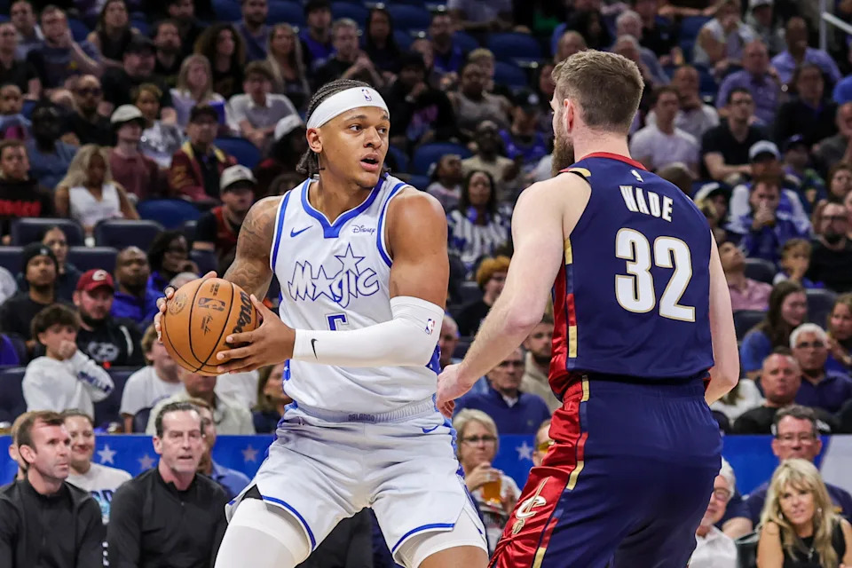 Mar 11, 2026; Orlando, Florida, USA; Orlando Magic forward Paolo Banchero (5) looks to pass in front of Cleveland Cavaliers forward Dean Wade (32) during the first quarter at Kia Center. Mandatory Credit: Mike Watters-Imagn Images