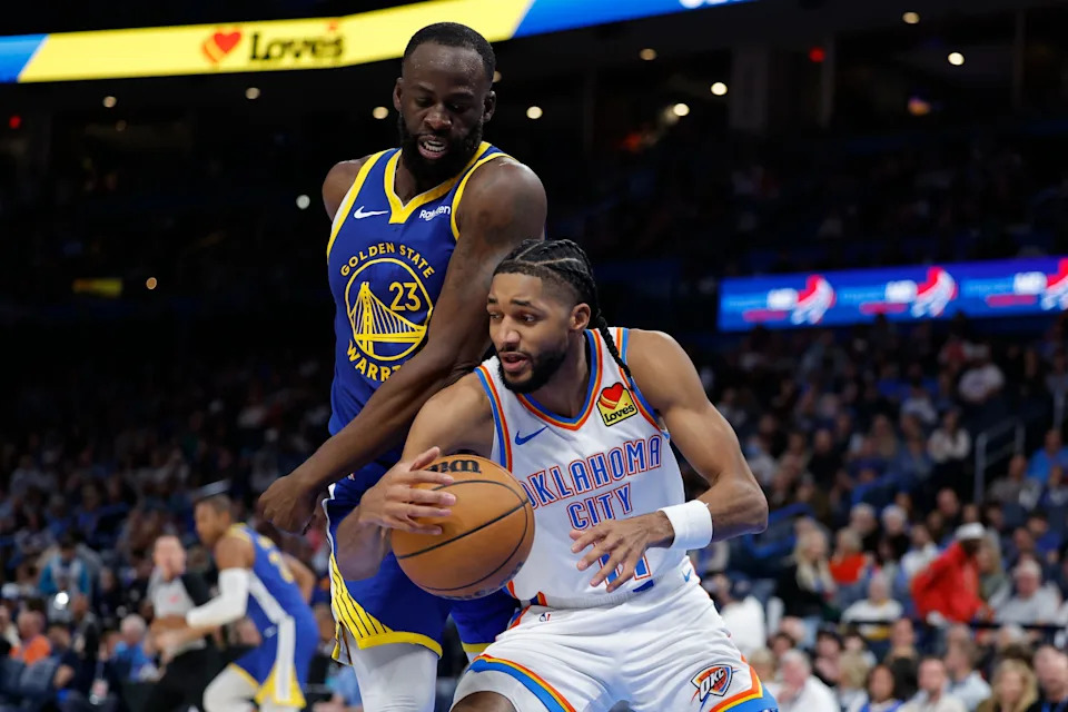 Mar 7, 2026; Oklahoma City, Oklahoma, USA; Oklahoma City Thunder guard Isaiah Joe (11) moves the ball around Golden State Warriors forward Draymond Green (23) during the second half at Paycom Center. Mandatory Credit: Alonzo Adams-Imagn Images