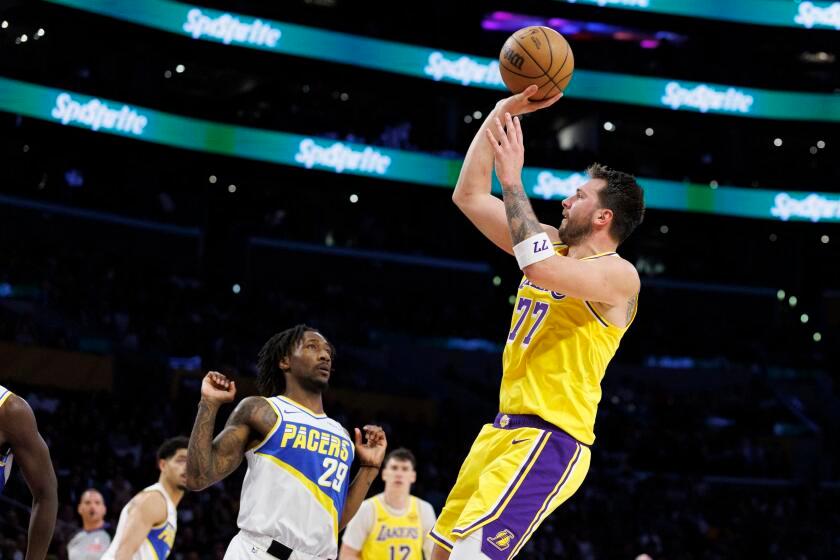 Lakers guard Luka Doncic scores in front of Indiana Pacers guard Quenton Jackson Friday at Crypto.com Arena.