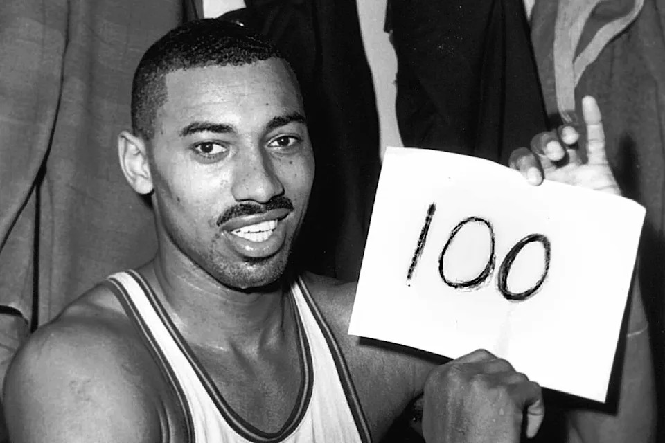 FILE - Philadelphia Warriors' Wilt Chamberlain holds a sign reading, "100," in the dressing room after he scored 100 points against the New York Knickerbockers, March 2, 1962, in Hershey, Pa. (AP Photo/Paul Vathis, File)