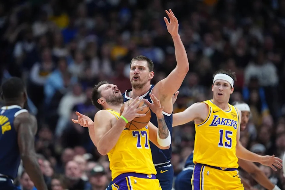 Nikola Jokić and Austin Reaves watching Luka Dončić after he was hit in the face by the ball. AP