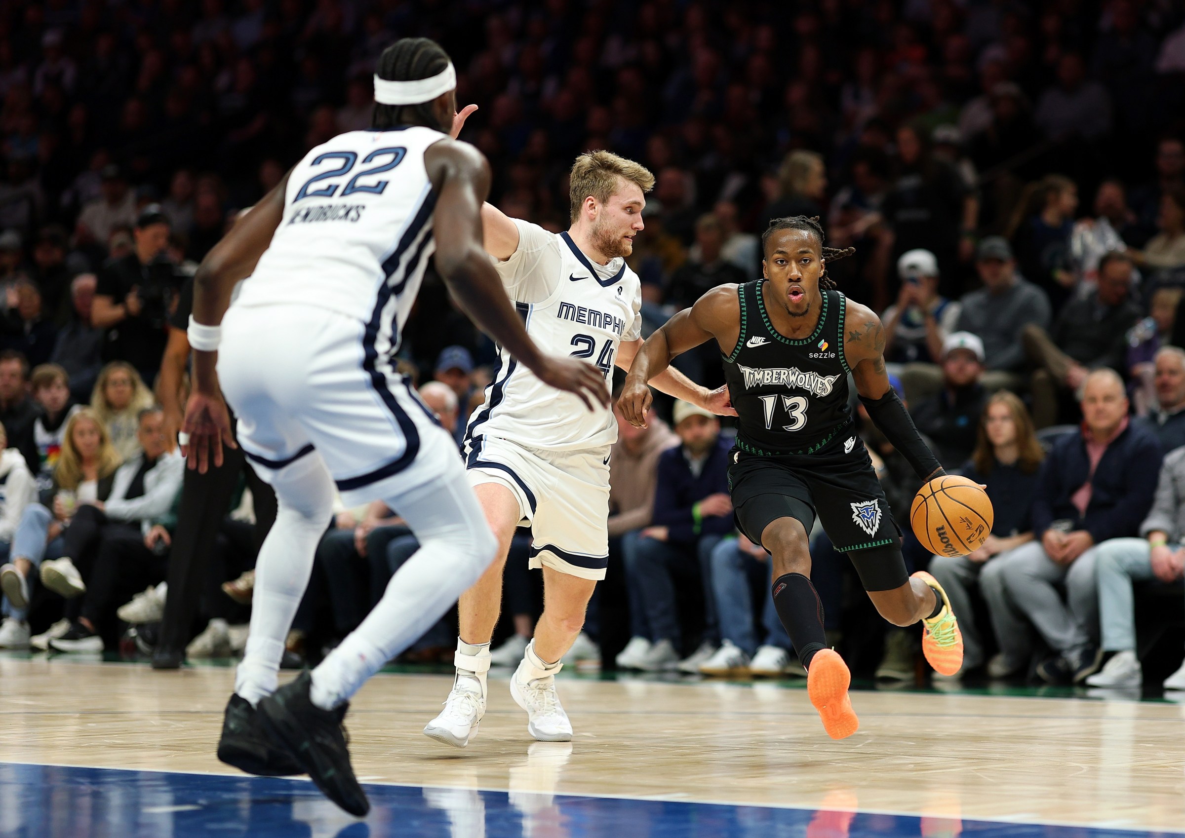 MINNEAPOLIS, MINNESOTA - MARCH 03: Ayo Dosunmu #13 of the Minnesota Timberwolves drives to the basket against Cam Spencer #24 and Taylor Hendricks #22 of the Memphis Grizzlies in the third quarter at Target Center on March 03, 2026 in Minneapolis, Minnesota. The Timberwolves defeated the Grizzlies 117-110. NOTE TO USER: User expressly acknowledges and agrees that, by downloading and or using this photograph, User is consenting to the terms and conditions of the Getty Images License Agreement. (Photo by David Berding/Getty Images)