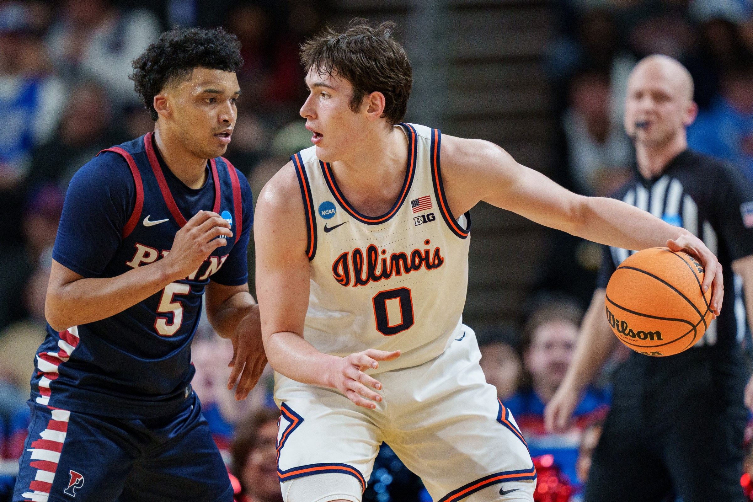 GREENVILLE, SOUTH CAROLINA - MARCH 19: Cam Thrower #5 of the Pennsylvania Quakers guards David Mirkovic #0 of the Illinois Fighting Illini in the first half during the first round of the NCAA Men’s Basketball Tournament at Bon Secours Wellness Arena on March 19, 2026 in Greenville, South Carolina. (Photo by Jacob Kupferman/Getty Images)