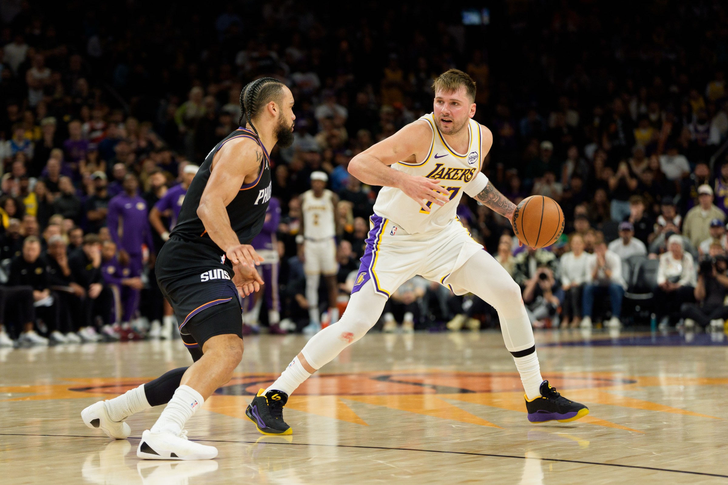 Dec 14, 2025; Phoenix, Arizona, USA; Los Angeles Lakers guard Luka Doncic (77) dribbles the ball as Phoenix Suns forward Dillon Brooks (3) defends during the second half of play at Mortgage Matchup Center. Mandatory Credit: Allan Henry-Imagn Images