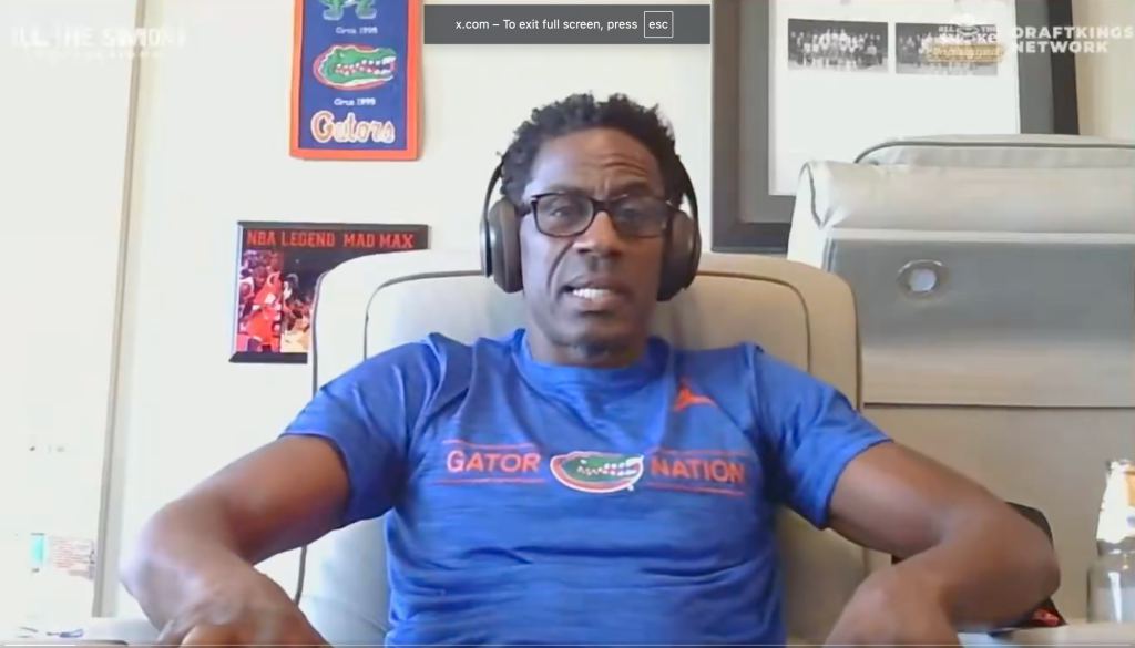 Former NBA player Stephen Jackson wearing a blue "Gator Nation" shirt and headphones.