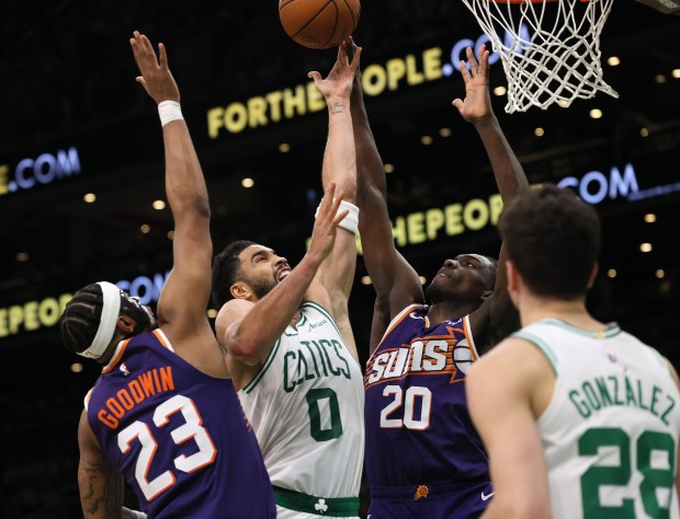 Boston, MA - Boston Celtics forward Jayson Tatum (0) puts up the ball defended by Phoenix Suns guard Jordan Goodwin (23) and forward Rasheer Fleming (20)during the third quarter of the game at TD Garden. (Nancy Lane/Boston Herald)