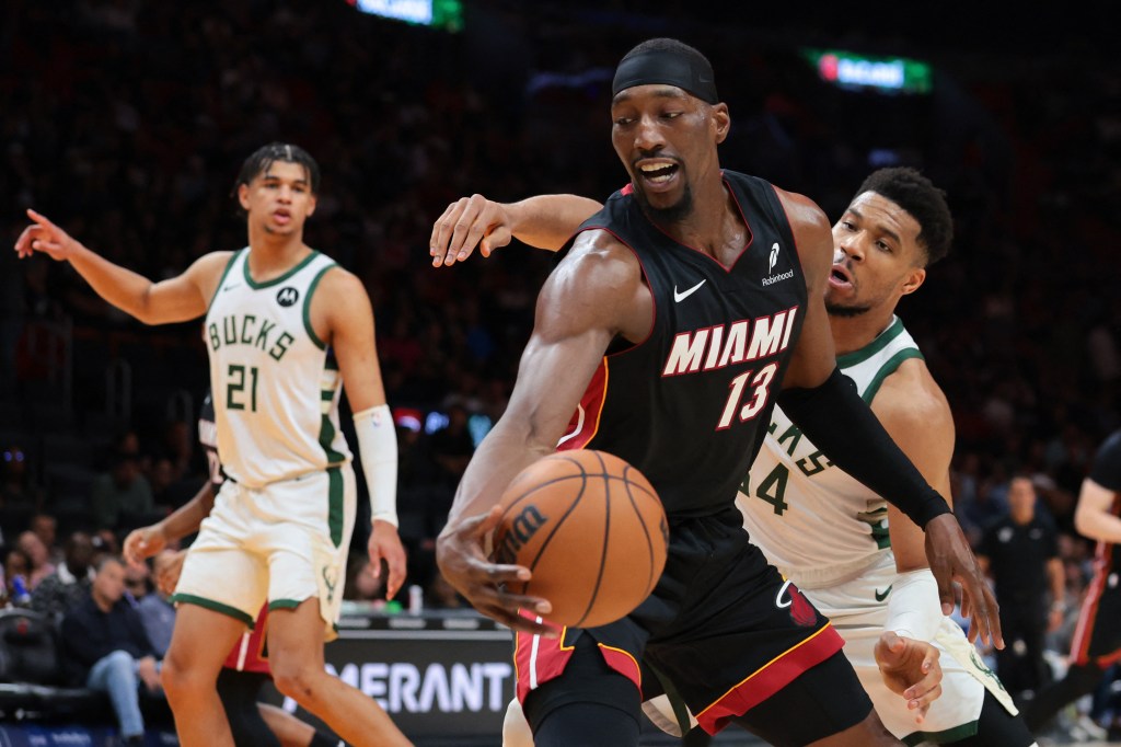 Miami Heat center Bam Adebayo (13) protects the basketball against Milwaukee Bucks forward Giannis Antetokounmpo (34).