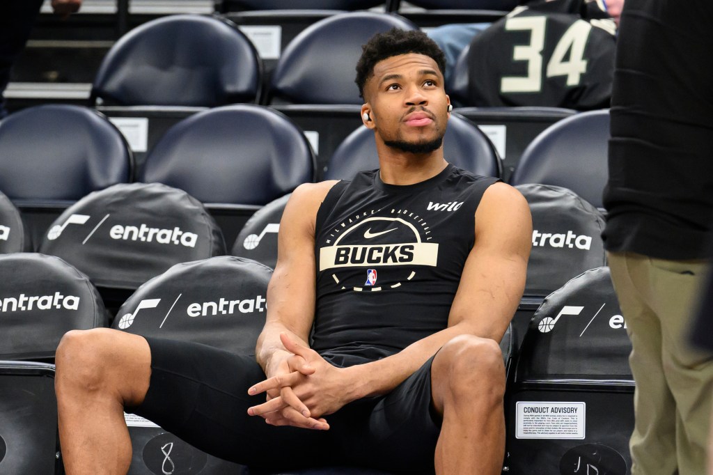 Giannis Antetokounmpo watching the warmup session from the bench.