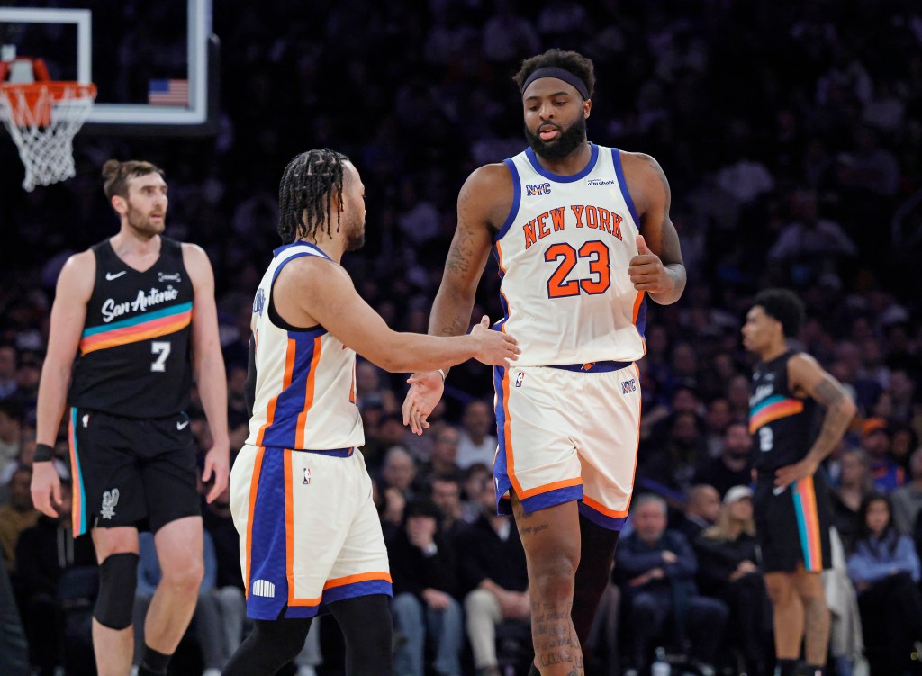 New York Knicks players Mitchell Robinson and Jalen Brunson high-fiving.
