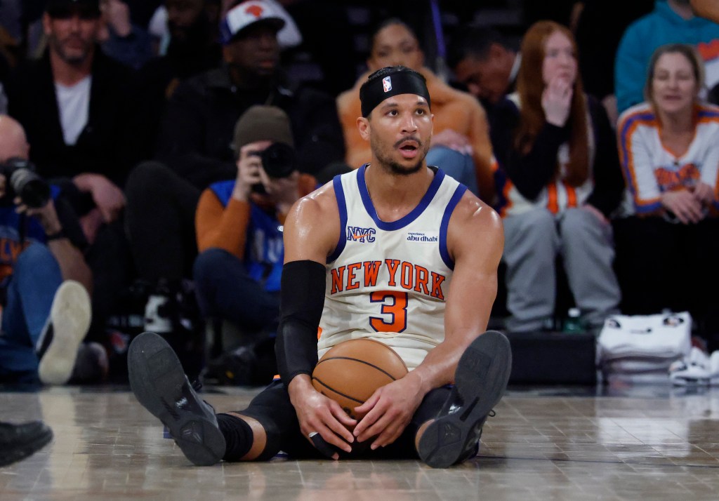 New York Knicks guard Josh Hart sitting on the court during a game.