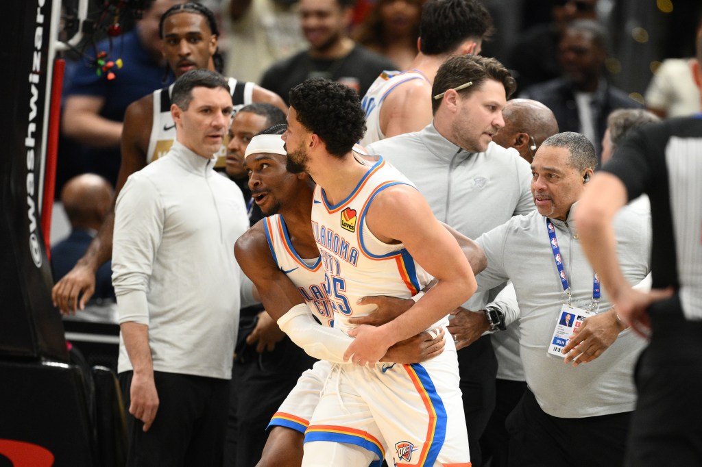 Oklahoma City Thunder guard Shai Gilgeous-Alexander holding guard Ajay Mitchell as staff step in during a scuffle.