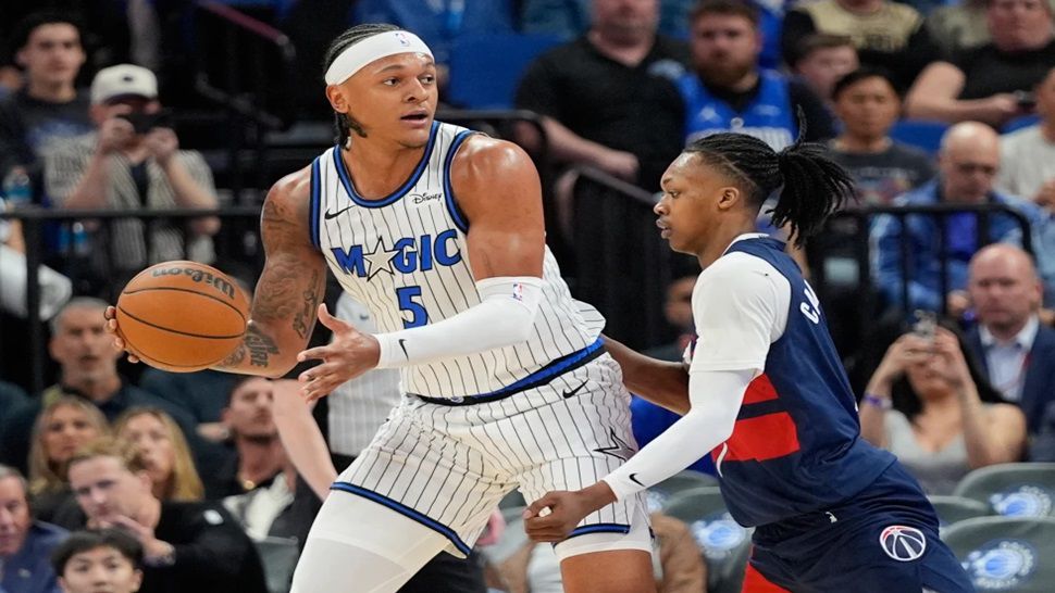 Orlando Magic forward Paolo Banchero (5) looks to pass the ball as Washington Wizards guard Bub Carrington defends during the first half of an NBA basketball game, Tuesday, March 3, 2026, in Orlando, Fla. (AP Photo/John Raoux)