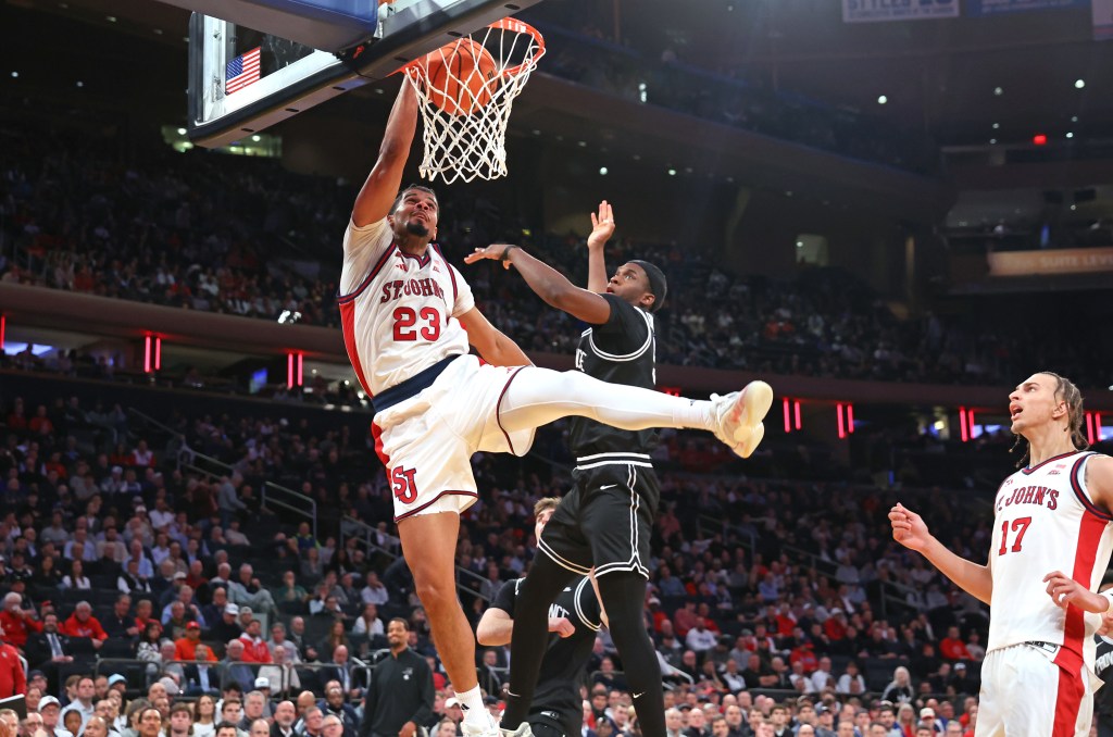 St. John's Red Storm forward Bryce Hopkins #23 dunks over Providence Friars forward Oswin Erhunmwunse #55.