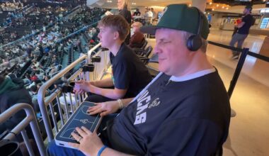Steve Heesen and his son at a Bucks game. Heesen is using a tactile broadcast device to follow along with the game. (Abbey Taylor/Spectrum News 1)