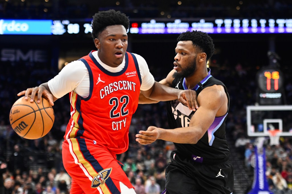 Derik Queen of the New Orleans Pelicans drives past Elijah Harkless of the Utah Jazz.