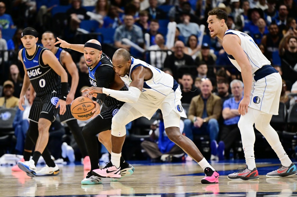 Jalen Suggs #4 of the Orlando Magic steals the ball from Khris Middleton #20 of the Dallas Mavericks in the second half of their game.