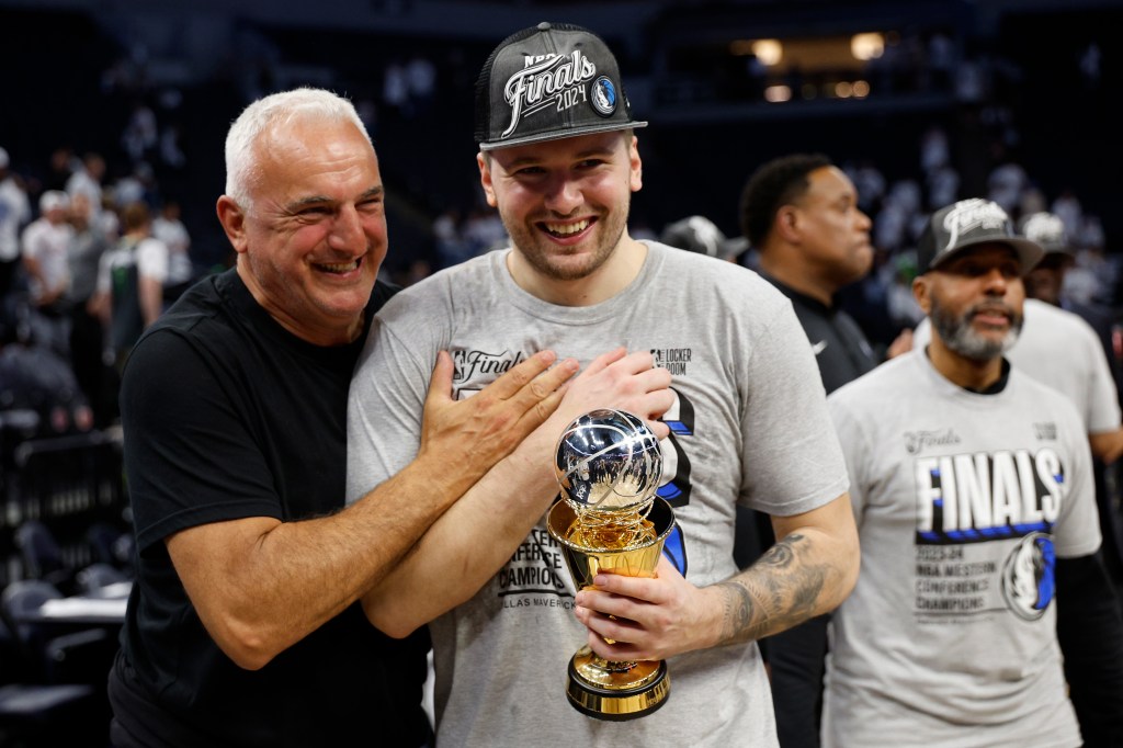 Luka Doncic and his father Sasa embrace, holding the Western Conference Finals trophy.
