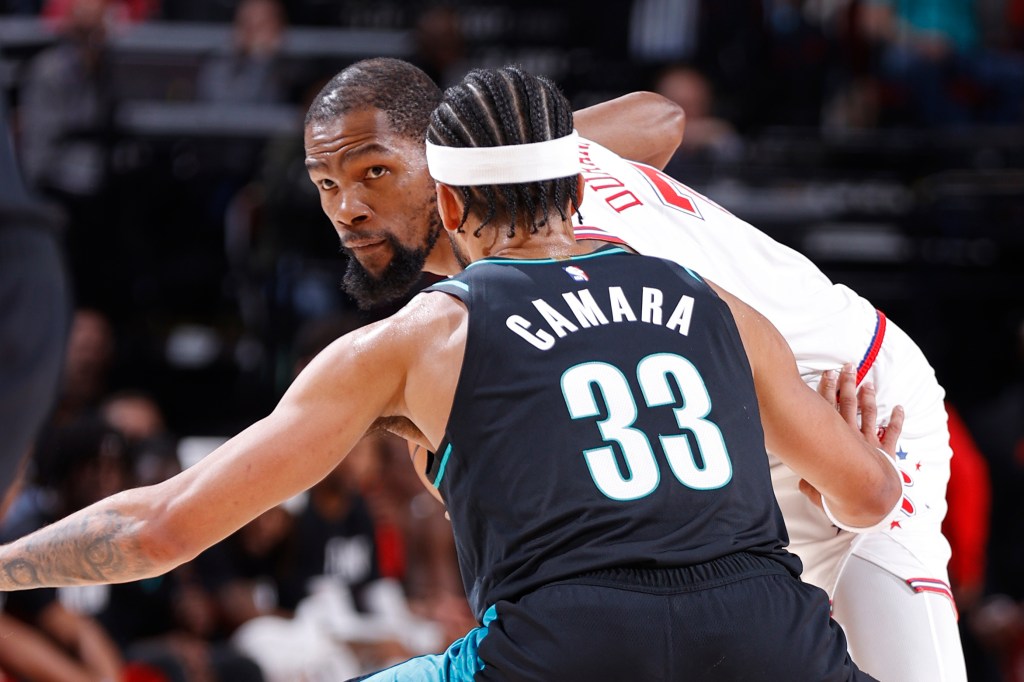 Kevin Durant of the Houston Rockets handles the ball against a Portland Trail Blazers player.