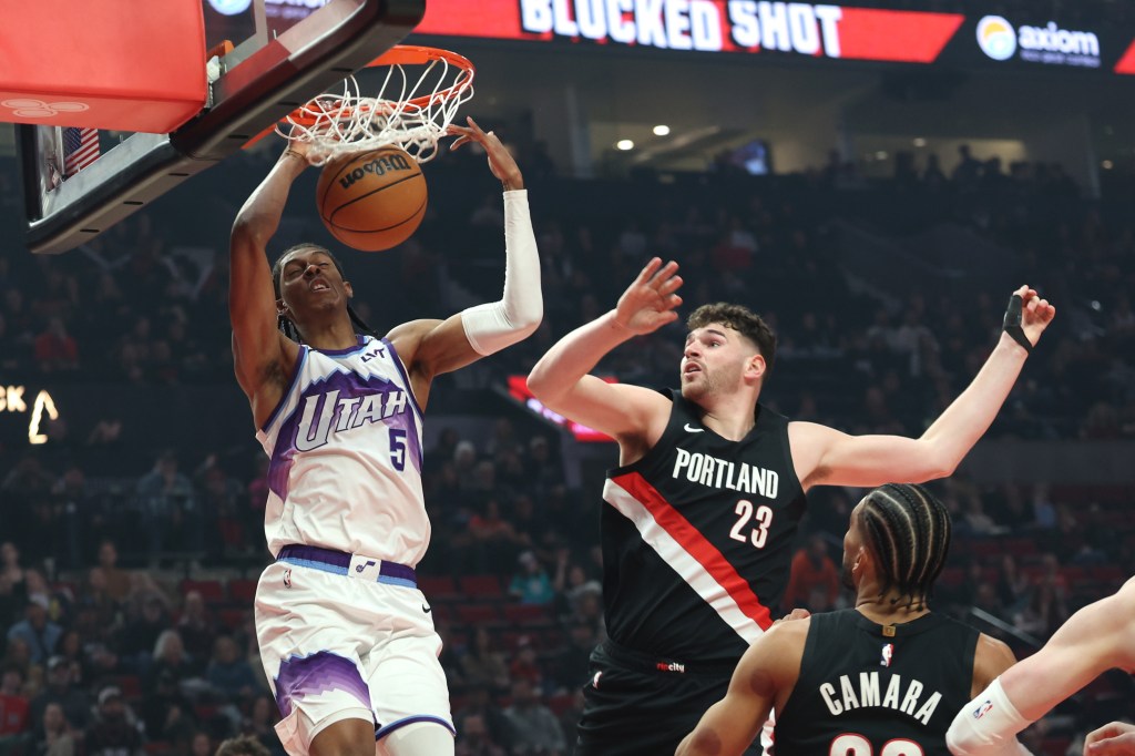 Utah Jazz forward Cody Williams (5) dunks the ball over Portland Trail Blazers center Donovan Clingan (23) during the first half at Moda Center. 