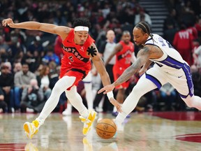 Toronto Raptors' Scottie Barnes (4) and Sacramento Kings' DeMar DeRozan (10) battle for the ball.
