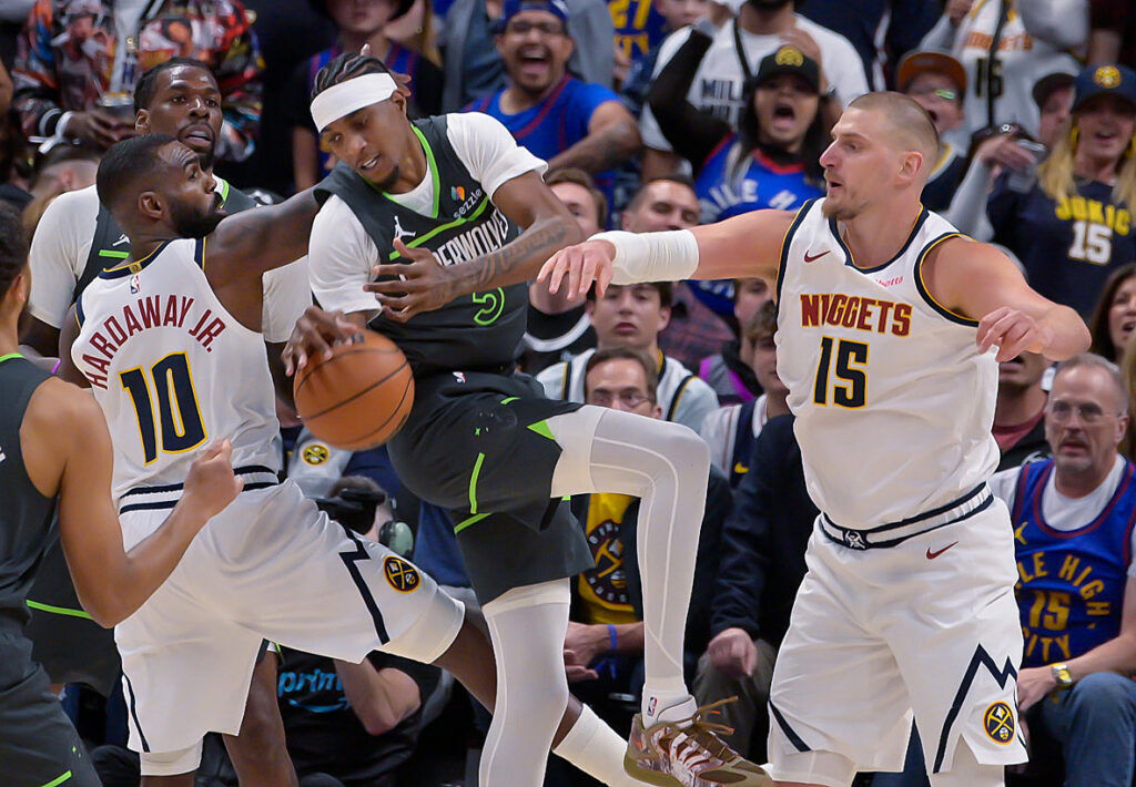 Denver Nuggets guard Tim Hardaway Jr. (10) and Denver Nuggets center Nikola Jokic (15) defend Minnesota Timberwolves forward Jaden McDaniels (3) during game 1 of round 1 of the NBA Championships at Ball Arena on Saturday, April 19, 2026. The Nuggets won the game 116-105. (The Gazette, Jerilee Bennett)