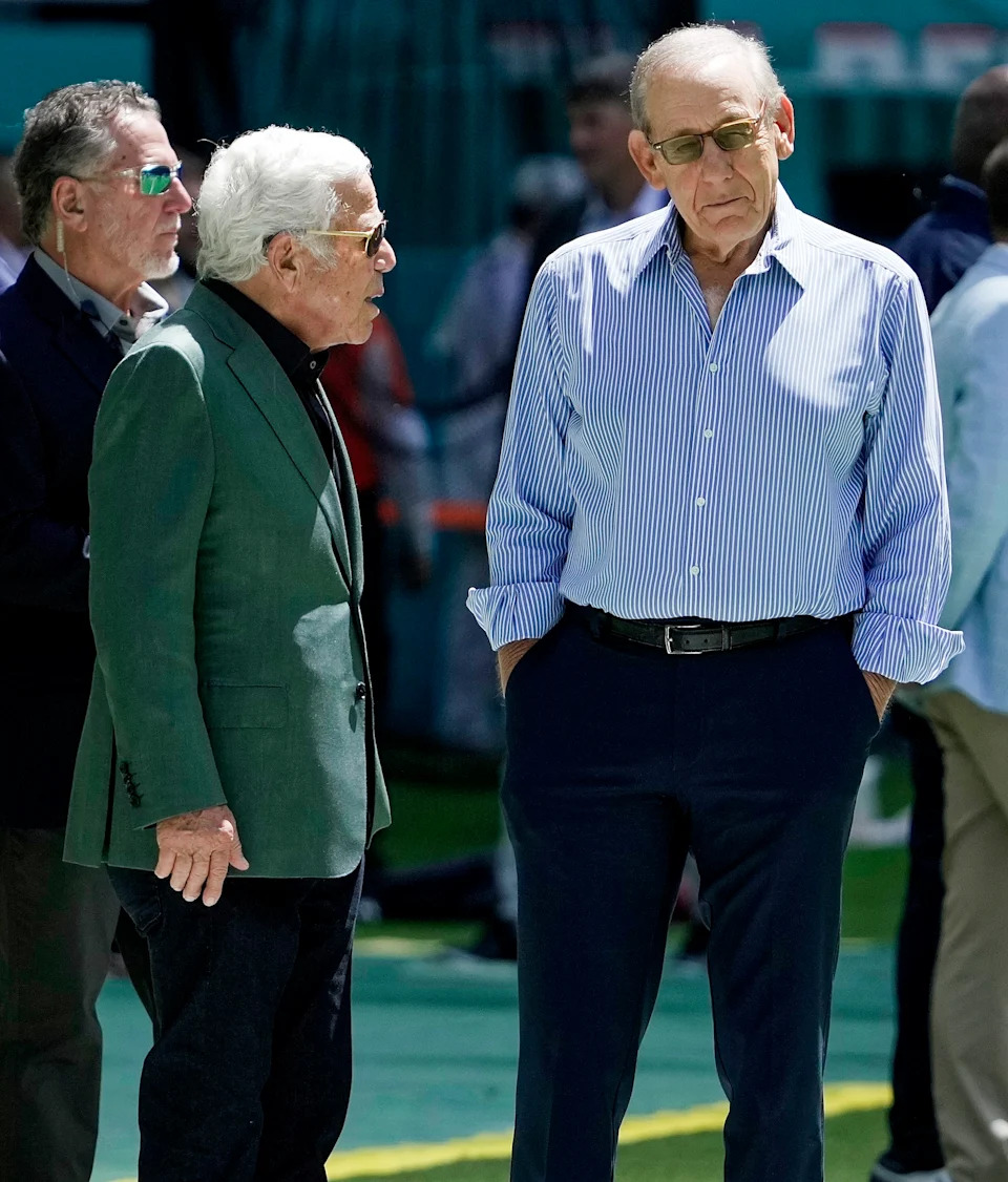 Dolphins owner Stephen Ross (R) and Patriots owner Robert Kraft chat on the field before a game last season. (Barry Chin/The Boston Globe via Getty Images)