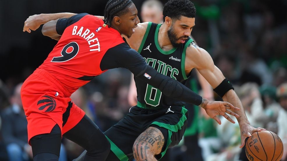 Boston Celtics forward Jayson Tatum, right, tries to drive past Toronto Raptors forward RJ Barrett in the first half of an NBA basketball game, Sunday, April 5, 2026, in Boston. (AP Photo/Steven Senne)