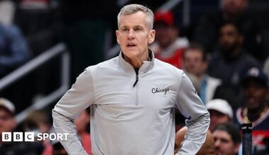 Billy Donovan is wearing a grey top and has his hands on his hips