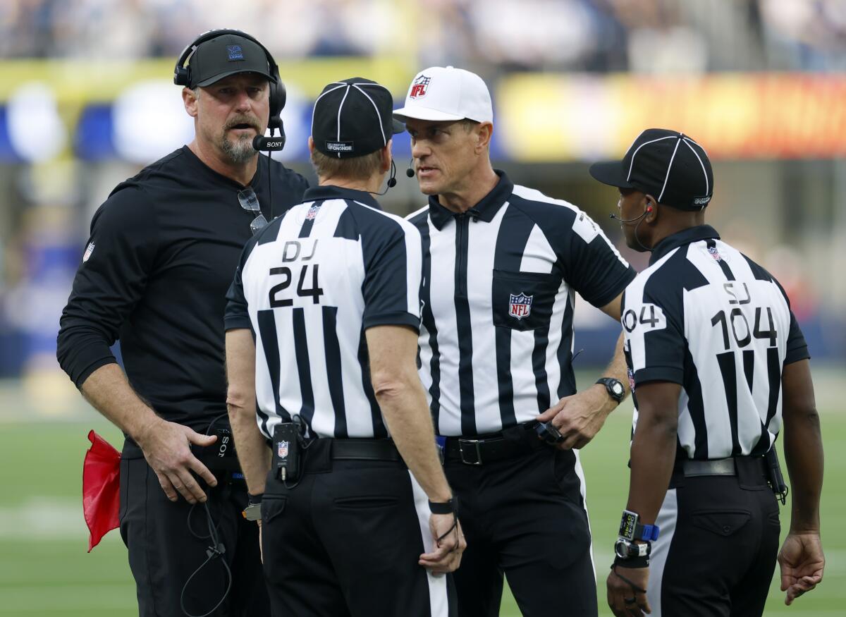 Detroit Lions coach Dan Campbell, left, speaks with referees during a game against the Rams at SoFi Stadium in December.