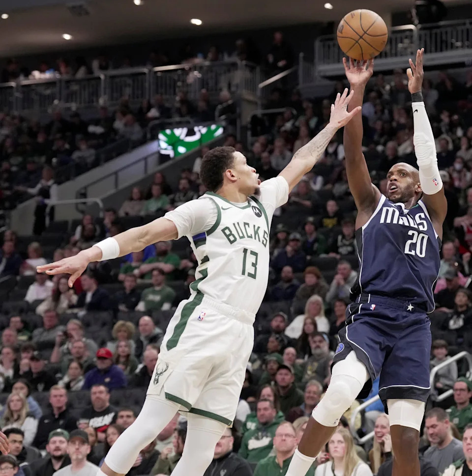 Dallas Mavericks forward Khris Middleton (20) shoots over Milwaukee Bucks guard Ryan Rollins (13) during the first half of their game Tuesday, March 31, 2026 at Fiserv Forum in Milwaukee, Wisconsin.