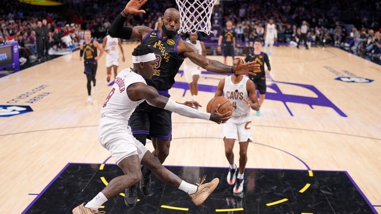 Cleveland Cavaliers guard Dennis Schroder, left, passes the ball as...