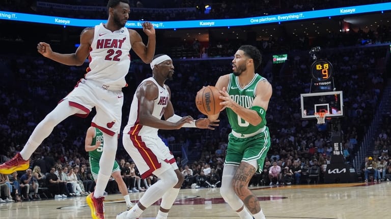 Miami Heat forward Andrew Wiggins (22) and center Bam Adebayo,...