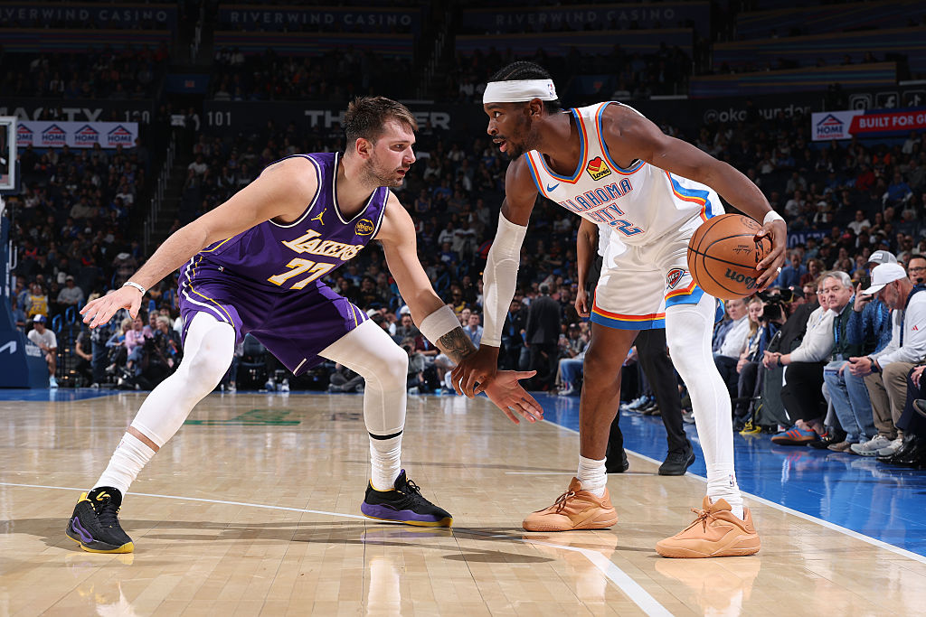 OKLAHOMA CITY, OK - NOVEMBER 12: Shai Gilgeous-Alexander #2 of the Oklahoma City Thunder looks to pass the ball as Luka Doncic #77 of the Los Angeles Lakers plays defense during the game on November 12, 2025 at Paycom Center in Oklahoma City, Oklahoma. NOTE TO USER: User expressly acknowledges and agrees that, by downloading and or using this photograph, User is consenting to the terms and conditions of the Getty Images License Agreement. Mandatory Copyright Notice: Copyright 2025 NBAE (Photo by Joe Murphy/NBAE via Getty Images)