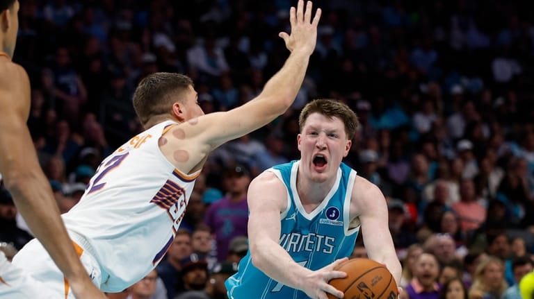 Charlotte Hornets guard Kon Knueppel, right, moves the ball against...