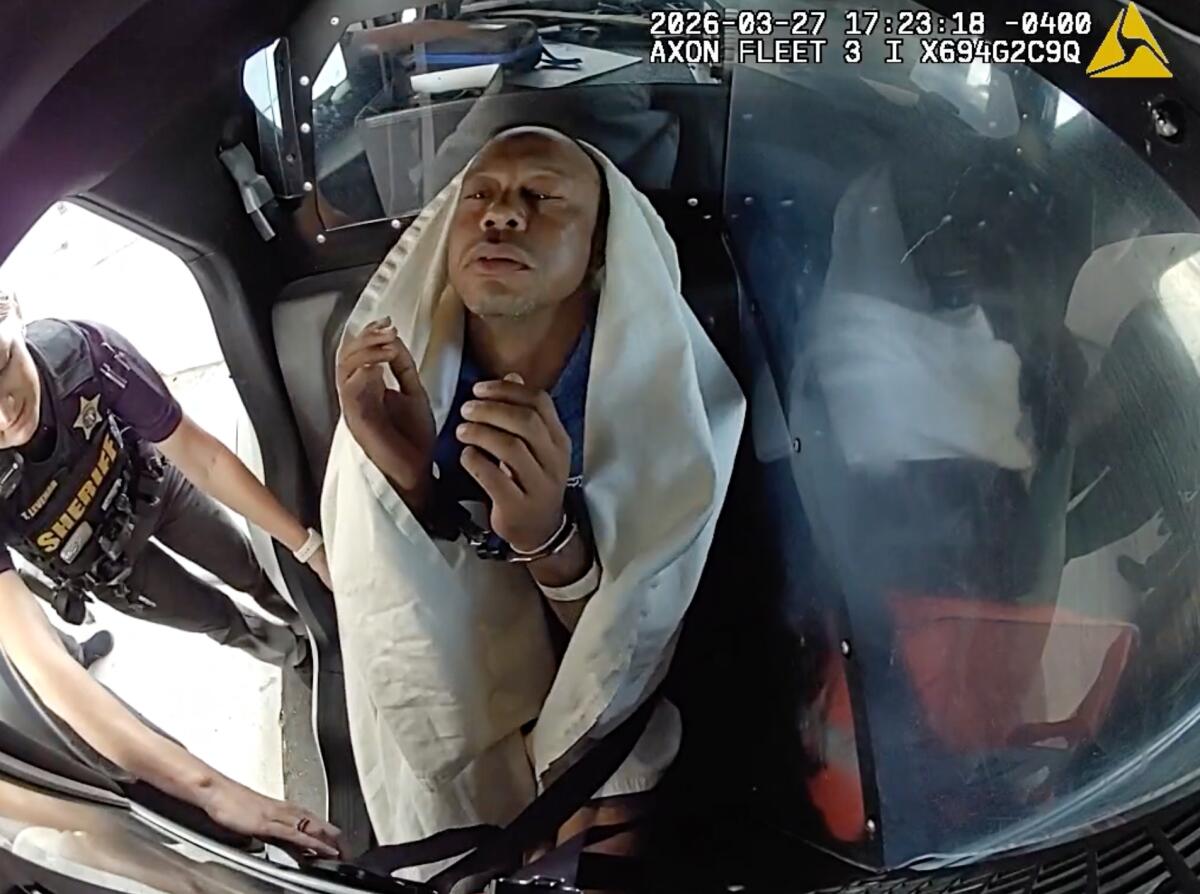 Tiger Woods is strapped into a police vehicle following a car crash in Jupiter Island, Fla., on March 27.