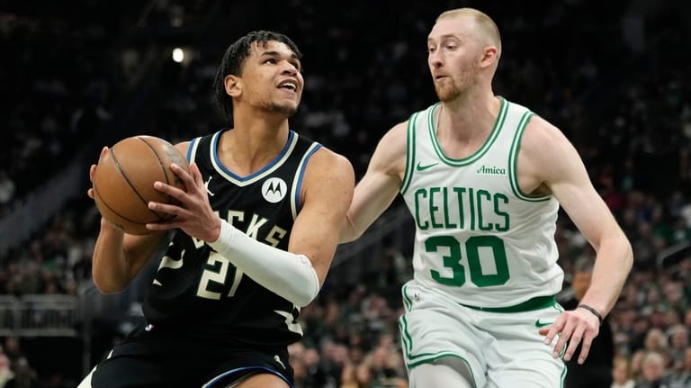 Milwaukee Bucks' Ousmane Dieng, left, drives to the basket against...