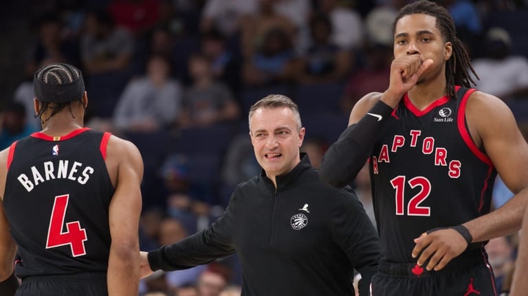 Toronto Raptors head coach Darko Rajakovic, center, reacts as he...