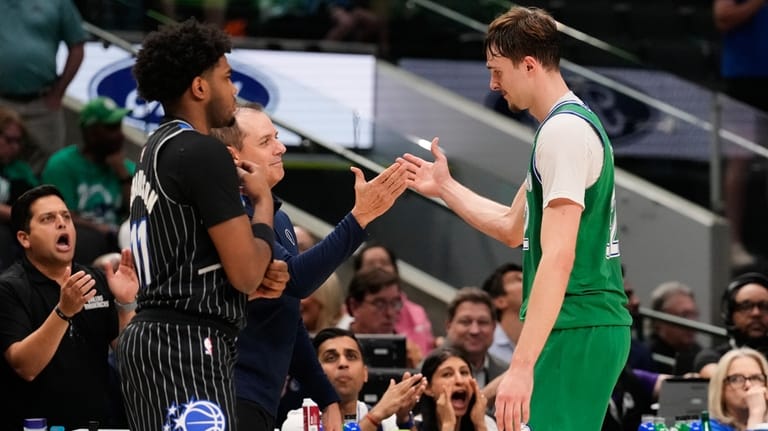 Dallas Mavericks forward Cooper Flagg, right, is greeted at the...