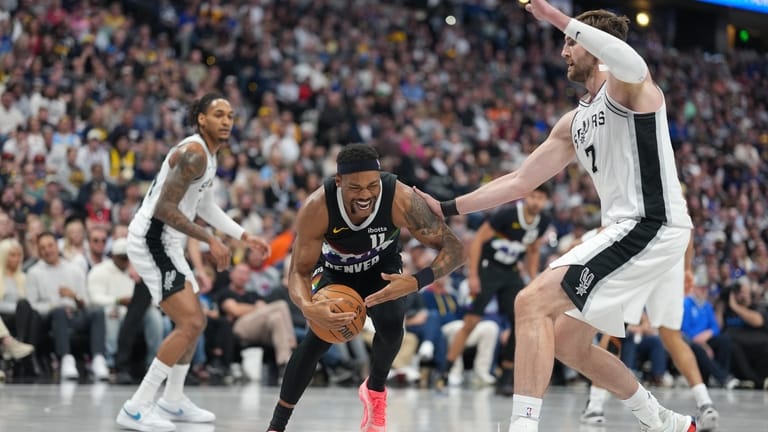 Denver Nuggets guard Bruce Brown, left, reacts after being injured...