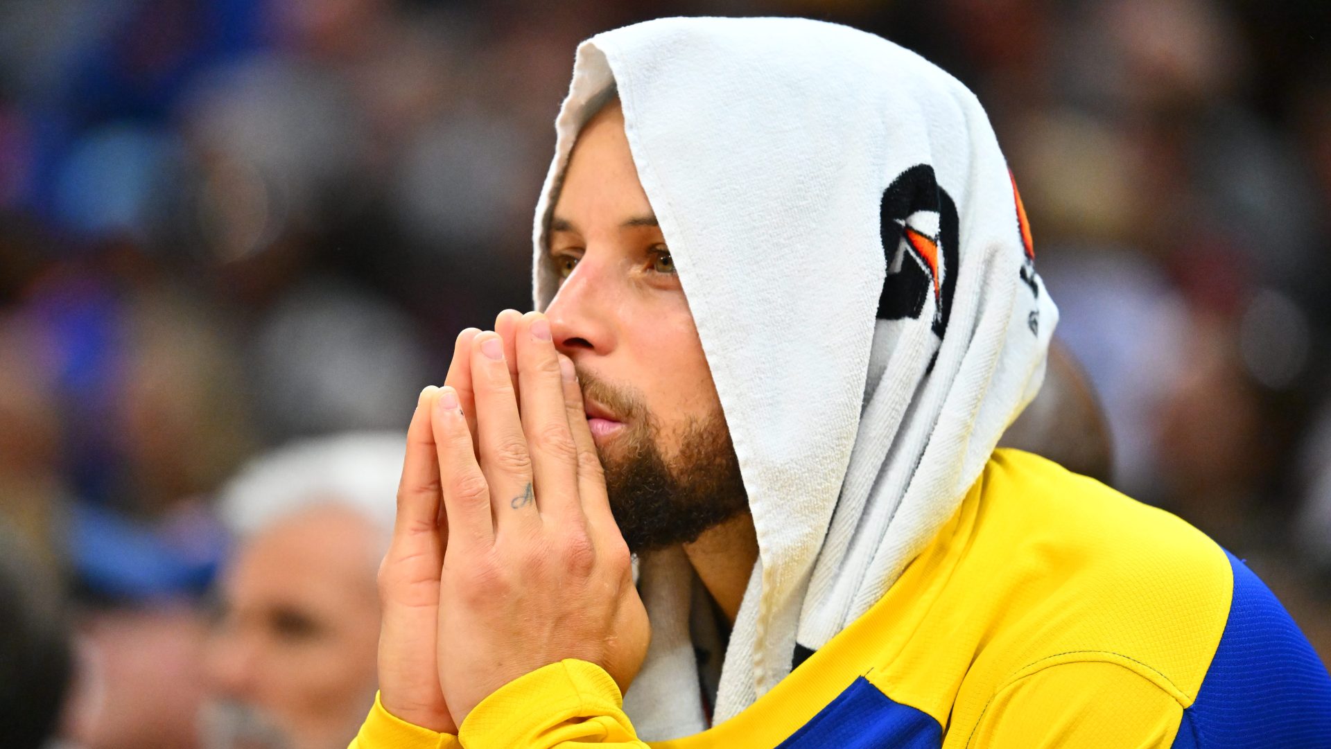 Stephen Curry of the Golden State Warriors watches from the bench.