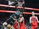 Neemias Queta of the Boston Celtics dunks the ball against Brandon Ingram of the Toronto Raptors.