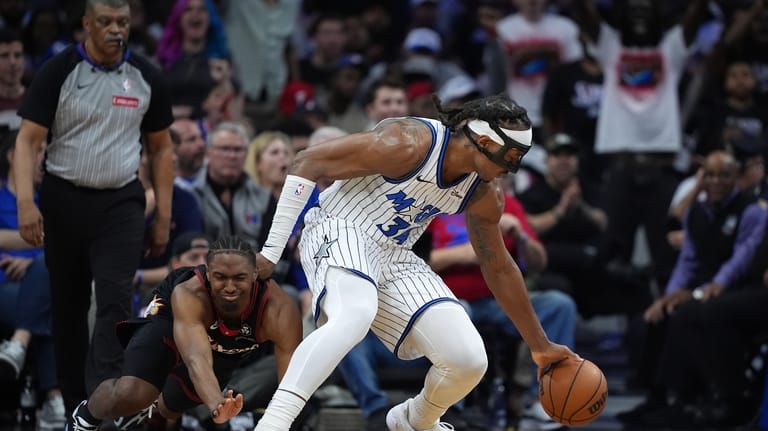 Orlando Magic's Wendell Carter Jr., right, keeps the ball away...
