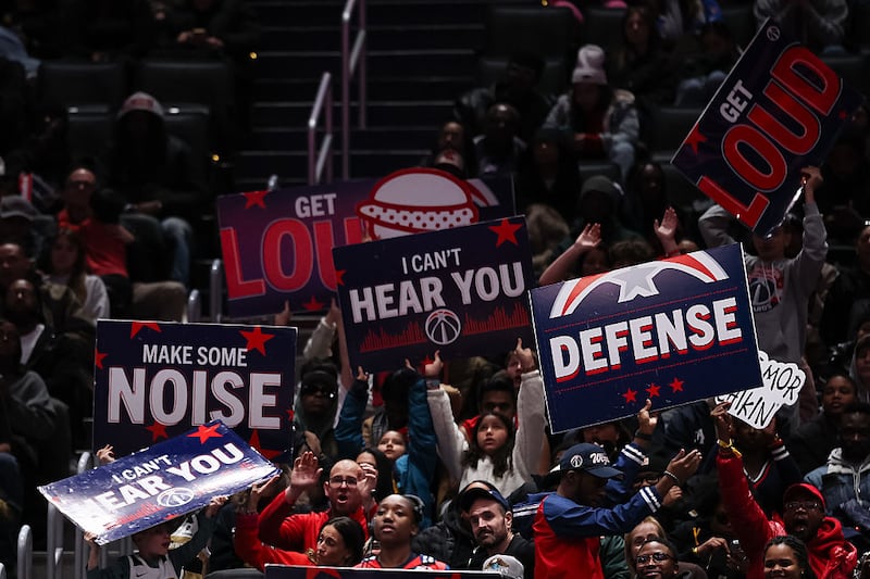 Fans hold signs during the second half of the game between the Washington Wizards and the Los Angeles Clippers at Capital One Arena on January 19, 2026.