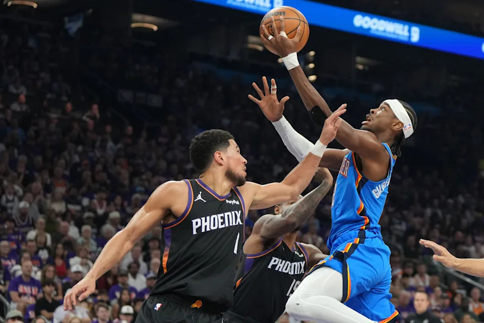 Apr 25, 2026; Phoenix, Arizona, USA; Oklahoma City Thunder guard Shai Gilgeous-Alexander (2) drives around Phoenix Suns guard Devin Booker (1) in the first half during game three of the first round of the 2026 NBA Playoffs at Mortgage Matchup Center. Mandatory Credit: Rick Scuteri-Imagn Images