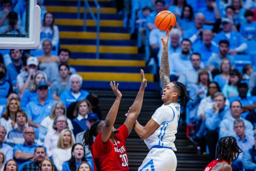 North Carolina forward Armando Bacot Jr. shoots over North Carolina State University forward DJ Burns Jr. King grew up watching his brother Armando and their parents navigate the business side of basketball.