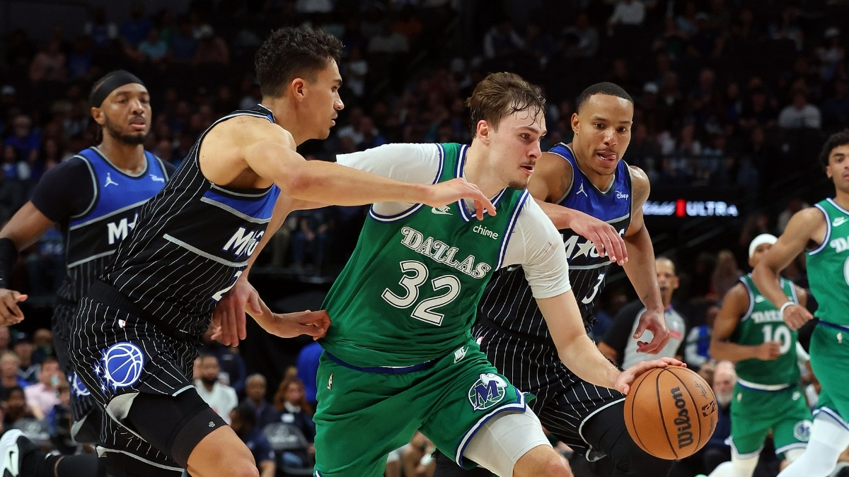 Cooper Flagg #32 of the Dallas Mavericks drives to the basket between Orlando Magic's Tristan da Silva and Desmond Bane during a historic 51-point game at American Airlines Center.